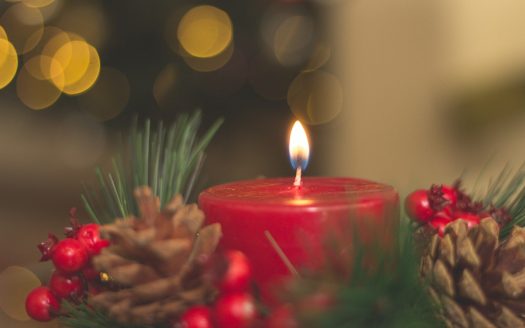 A candle to honor departed loved ones on Christmas